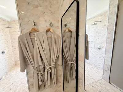a bathroom with a shower with a robe on display at Tesoro Villas in Río San Juan