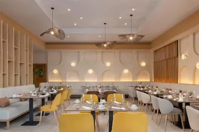 a dining room with tables and yellow chairs at Royal Beach Hotel Punta Cana, A JdV by Hyatt in Punta Cana