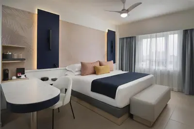 a bedroom with a bed and a table and a desk at Royal Beach Hotel Punta Cana, A JdV by Hyatt in Punta Cana