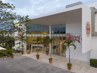 a building with palm trees in front of it at Royal Beach Hotel Punta Cana, A JdV by Hyatt in Punta Cana