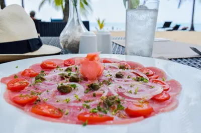 a plate of food with tomatoes on a table at Coson Bay in Las Terrenas