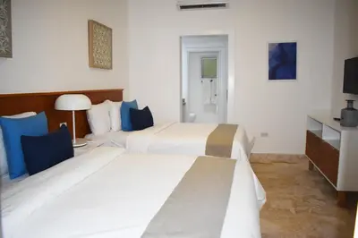 a hotel room with two beds and a tv at Coson Bay in Las Terrenas