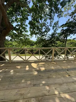 a wooden bridge with a tree in the background at Villas Las Indigenas in Imbert