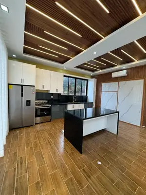 a large kitchen with a black and white counter top at Villas Las Indigenas in Imbert