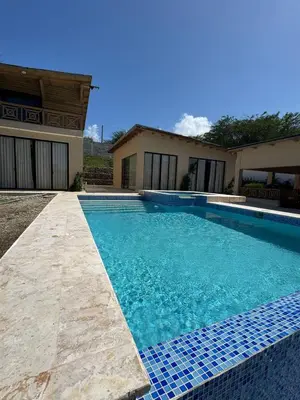a swimming pool in front of a house at Villas Las Indigenas in Imbert