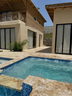 a swimming pool in front of a house at Villas Las Indigenas in Imbert