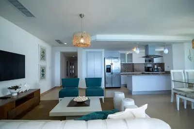 a living room with a couch and a kitchen at Condominio Marbella Juan Dolio in Villas del Mar