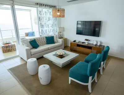 a living room with a couch and a tv at Condominio Marbella Juan Dolio in Villas del Mar