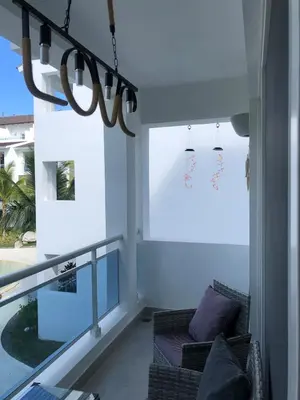 a living room with a couch and a large window at Cozy 2 bedroom Beach Apto in Bayahibe