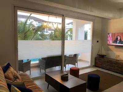 a living room with a couch and a large window at Cozy 2 bedroom Beach Apto in Bayahibe