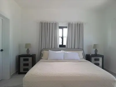 a bedroom with a large bed with two night stands at Modern 3 BR Villa with pool in gated community in Sosúa