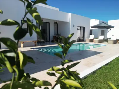 a villa with a swimming pool and a house at Modern 3 BR Villa with pool in gated community in Sosúa