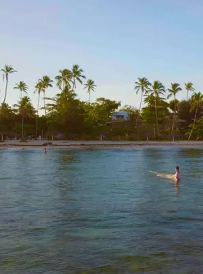 a person swimming in the water near a beach at JAVO BEACH the Nest in Las Galeras