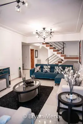 a living room with a blue couch and a staircase at Eclectic gorgeous, modern 3 levels penthouse in Santo Domingo