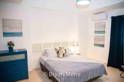 a bedroom with a bed and a blue dresser at Eclectic gorgeous, modern 3 levels penthouse in Santo Domingo