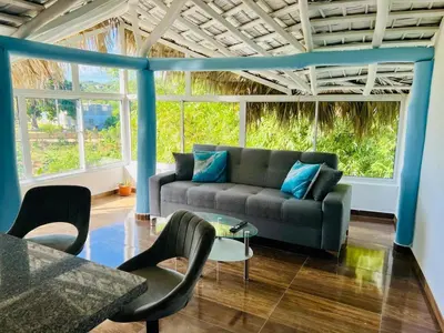 a living room with a couch and a table at The Coco Garden Cabin in Las Galeras
