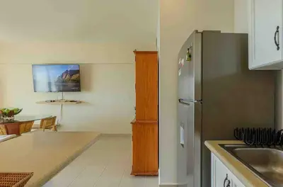 a kitchen with a stainless steel refrigerator and a table at Escape Beachfront Condo Costa del Sol Juan Dolio in Los Corrales