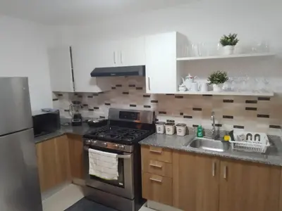 a kitchen with a stove top oven next to a sink at Apartamento Tipo resort-style space in Santiago de los Caballeros