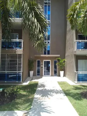 a building with palm trees in front of it at Apartamento Tipo resort-style space in Santiago de los Caballeros