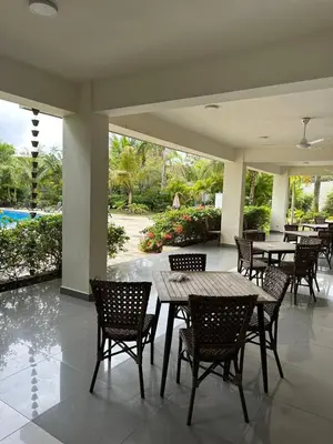 a patio with tables and chairs and a pool at Apartamento Tipo resort-style space in Santiago de los Caballeros