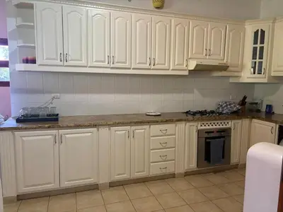 a kitchen with white cabinets and a counter top at Casa de Campo Golf, Villa La Romana in La Romana