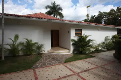 a white house with palm trees in front of it at Casa de Campo Golf, Villa La Romana in La Romana