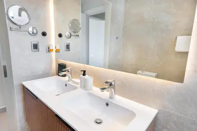 a bathroom with a white sink and a mirror at Corner Penthouse with Ocean and City Views with a Content Creator Hub in Punta Cana