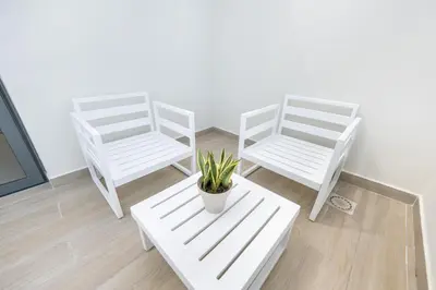 two white chairs and a bench with a potted plant at Corner Penthouse with Ocean and City Views with a Content Creator Hub in Punta Cana