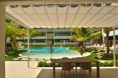 a pool with a table and chairs and a building at Corner Penthouse with Ocean and City Views with a Content Creator Hub in Punta Cana
