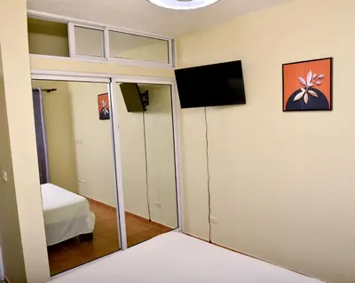 a room with a mirror and a tv on the wall at Peaceful 2 Bed Apartment - Pool & Private Beach Access in Punta Cana