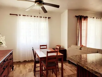 a living room with a table and chairs and a couch at Zen Apartment in Punta Cana
