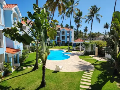a resort with a pool and palm trees at Zen Apartment in Punta Cana