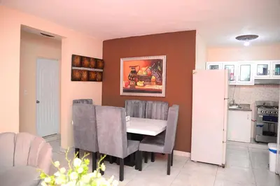 a kitchen and dining room with a table and chairs at HERMOS APARTAMENTo in Santiago de los Caballeros
