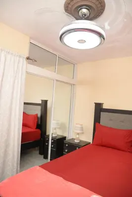 a bedroom with a red bed and a ceiling at HERMOS APARTAMENTo in Santiago de los Caballeros