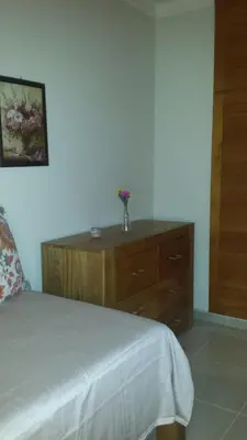 a bedroom with a dresser with a vase of flowers on it at Luxury Apartment close to centre of Jarabacoa in Jarabacoa