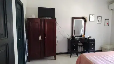 a bedroom with a dresser with a television and a mirror at villas bahia in Sánchez