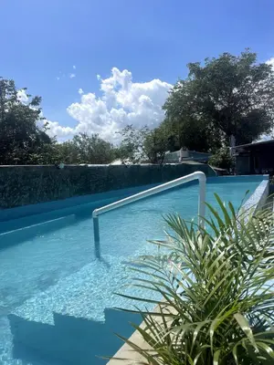 a swimming pool with a hand rail in the water at Habitacion 2 en Dani's Guest House in Las Galeras