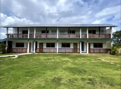 a large white building with a large yard at Habitacion 2 en Dani's Guest House in Las Galeras