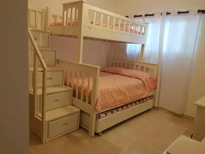 a childs bedroom with a bunk bed and stairs at Beautiful apartment in Playa Dorada in San Felipe de Puerto Plata