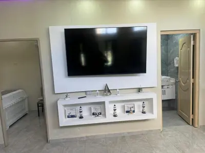 a living room with a television on a wall at Costa Azul Skibel 2 br in Santo Domingo
