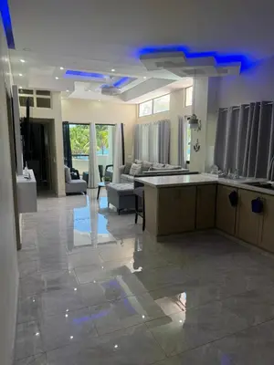 a large kitchen and living room with blue lights at Costa Azul Skibel 2 br in Santo Domingo