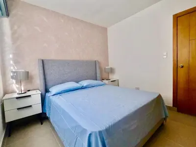 a bedroom with a bed with blue sheets and a nightstand at The Chic Hideout full apt in san isidro Terrace in Juan López