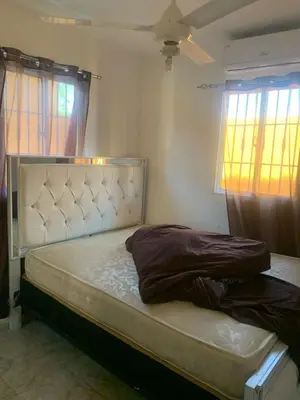 a bed in a bedroom with two windows at Casa modesta para disfrutar in Colorado