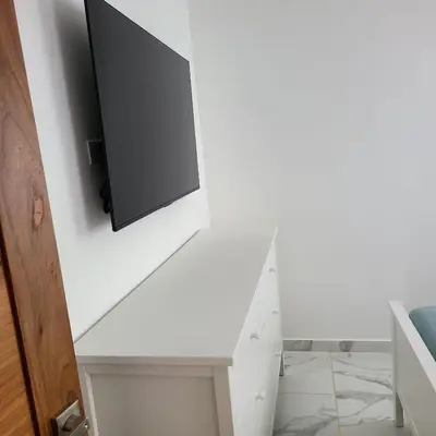 a living room with a tv on a white wall at Villa con piscina privada en Punta Cana in Punta Cana