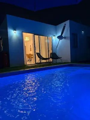 a house with a swimming pool at night at Villa con piscina privada en Punta Cana in Punta Cana