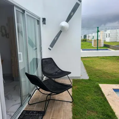 a black chair sitting on the side of a house at Villa con piscina privada en Punta Cana in Punta Cana