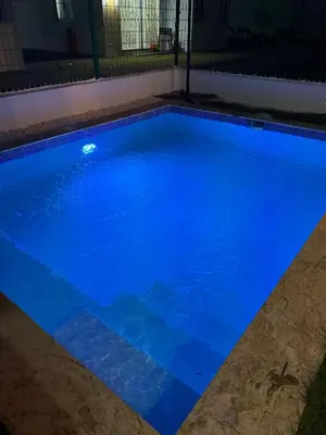 a swimming pool with blue water at night at Villa con piscina privada en Punta Cana in Punta Cana