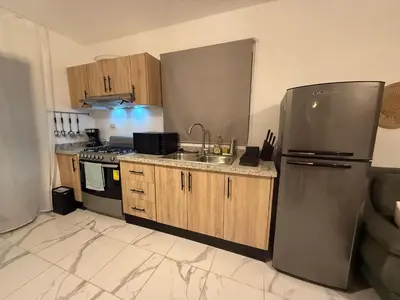 a kitchen with a stainless steel refrigerator and a sink at Villa con piscina privada en Punta Cana in Punta Cana