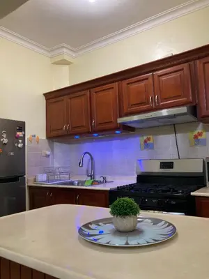 a kitchen with wooden cabinets and a plate on a counter at Residencial Don Pedro 1103 in Santo Domingo