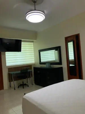 a bedroom with a bed and a flat screen tv at Residencial Don Pedro 1103 in Santo Domingo